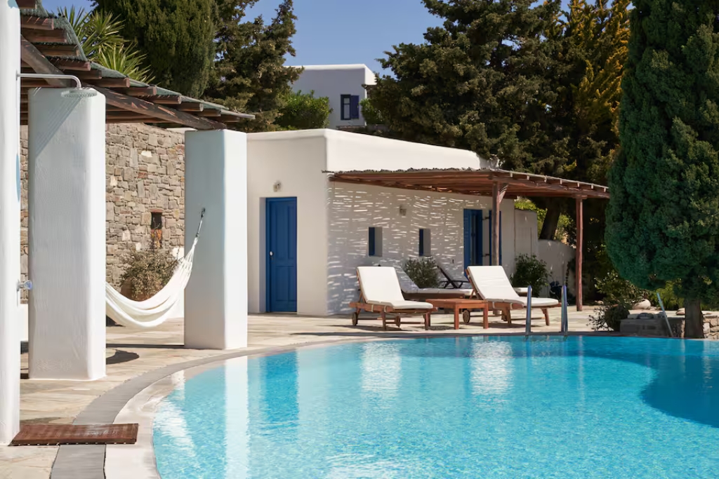 brick home in drios with blue doors an infinity pool hammocks and lounge chairs