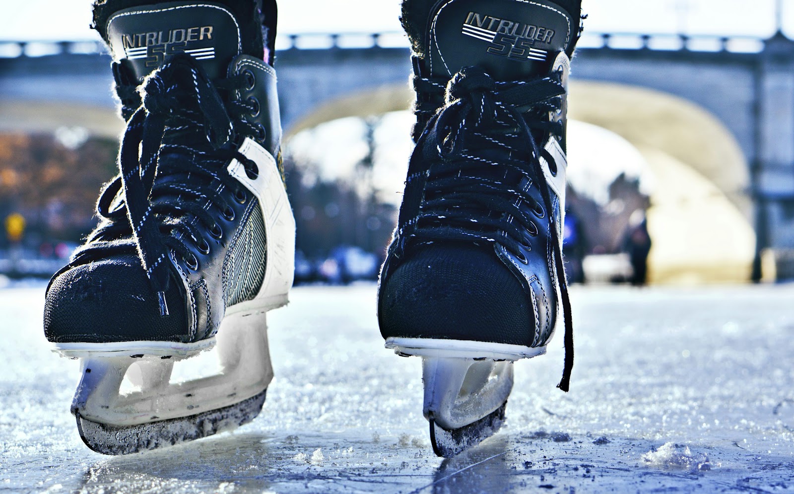 close-up photo of black-and-gray Intruder ice skates on frozen body of water