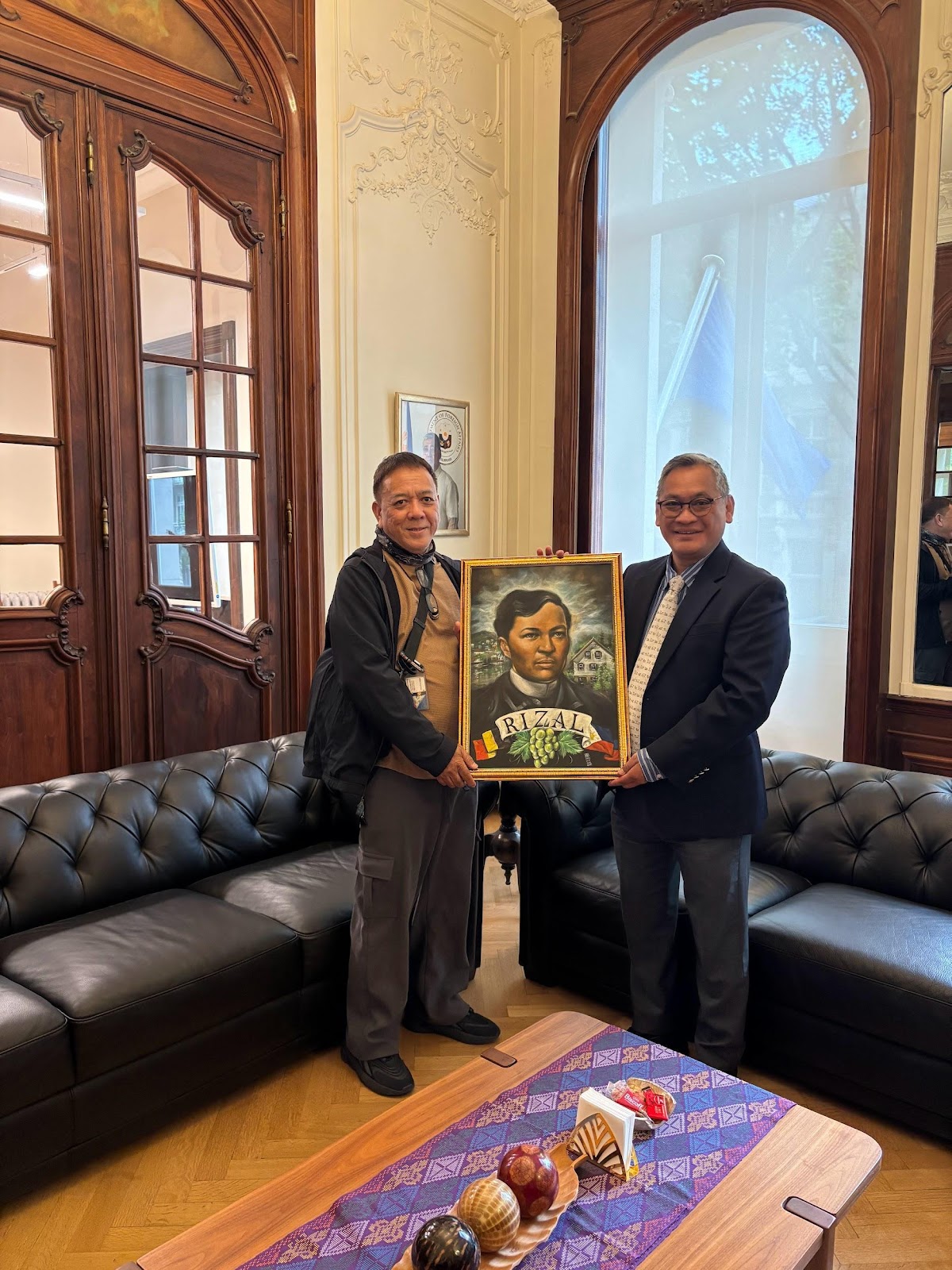 Two men holding a framed picture of a personAI-generated content may be incorrect.