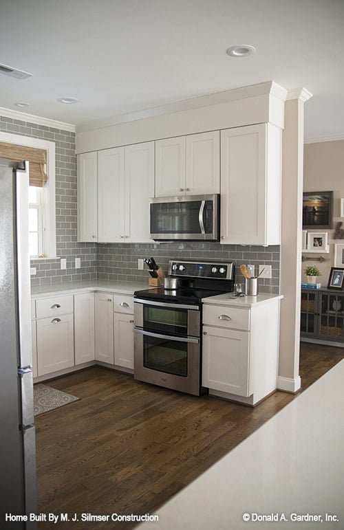 White cabinets, subway tile backsplash, and stainless steel appliances complete the kitchen.