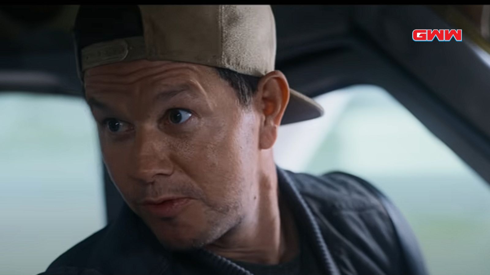 Mark Wahlberg glancing sideways with intensity in the cockpit.