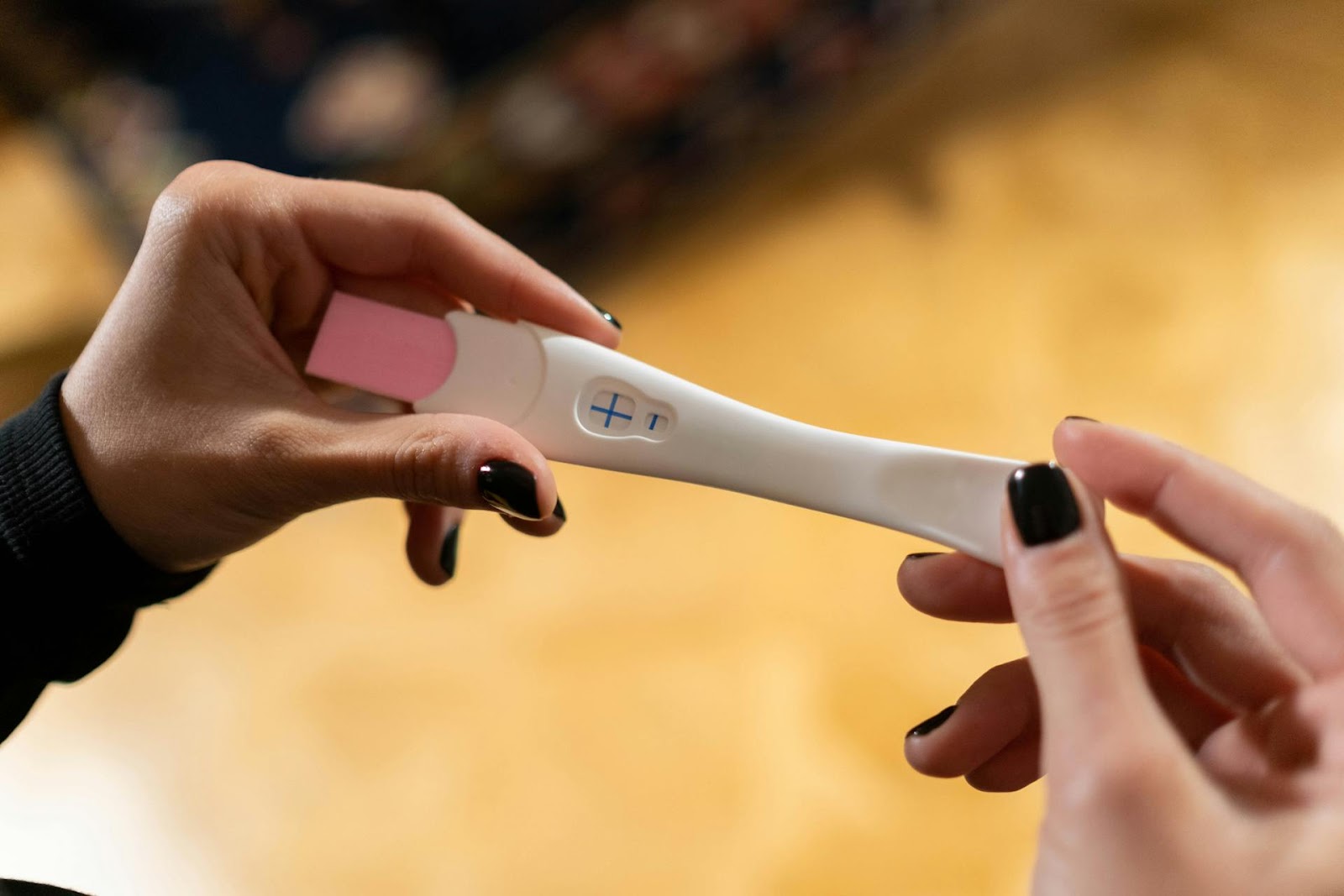 A woman holding a positive pregnancy test | Source: Pexels