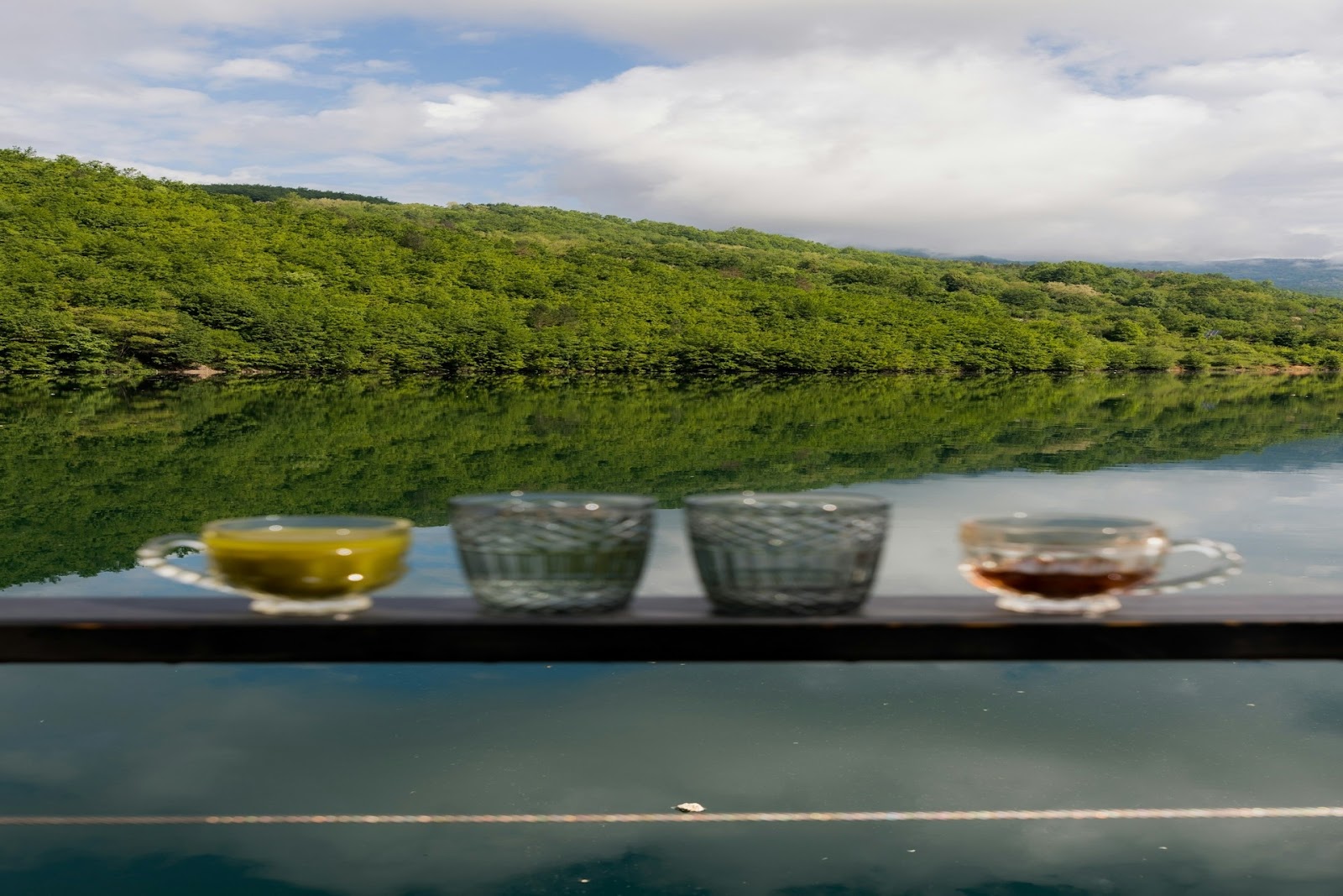 Water and tea in cups near water.