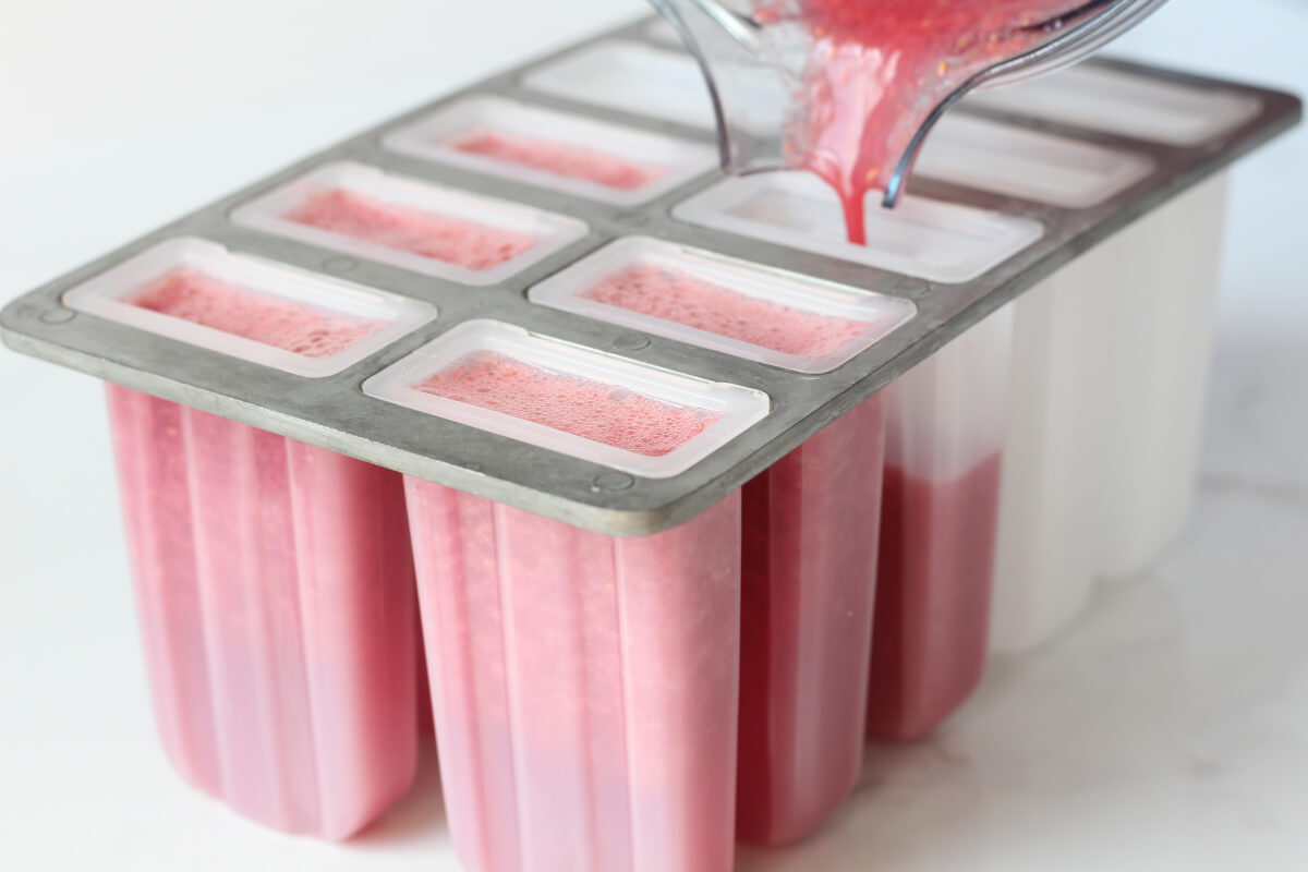 Pouring blended ingredients into popsicle mold