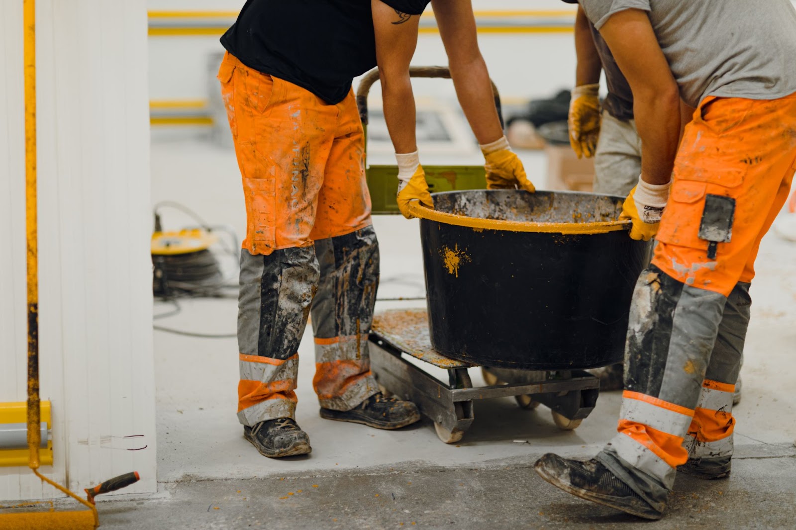 Workers from the waist down working with concrete. 