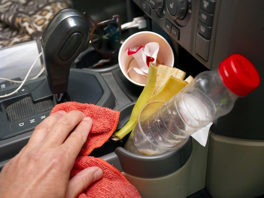 A hand cleaning a car with a red cloth

Description automatically generated