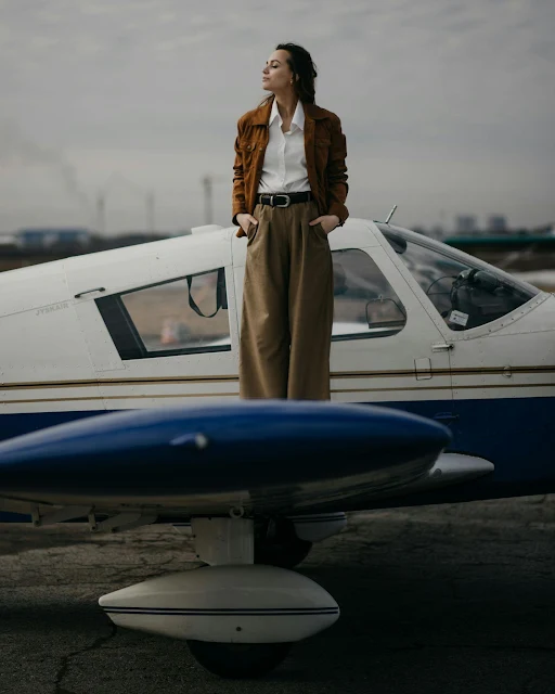 stylish woman standing outside small private plane