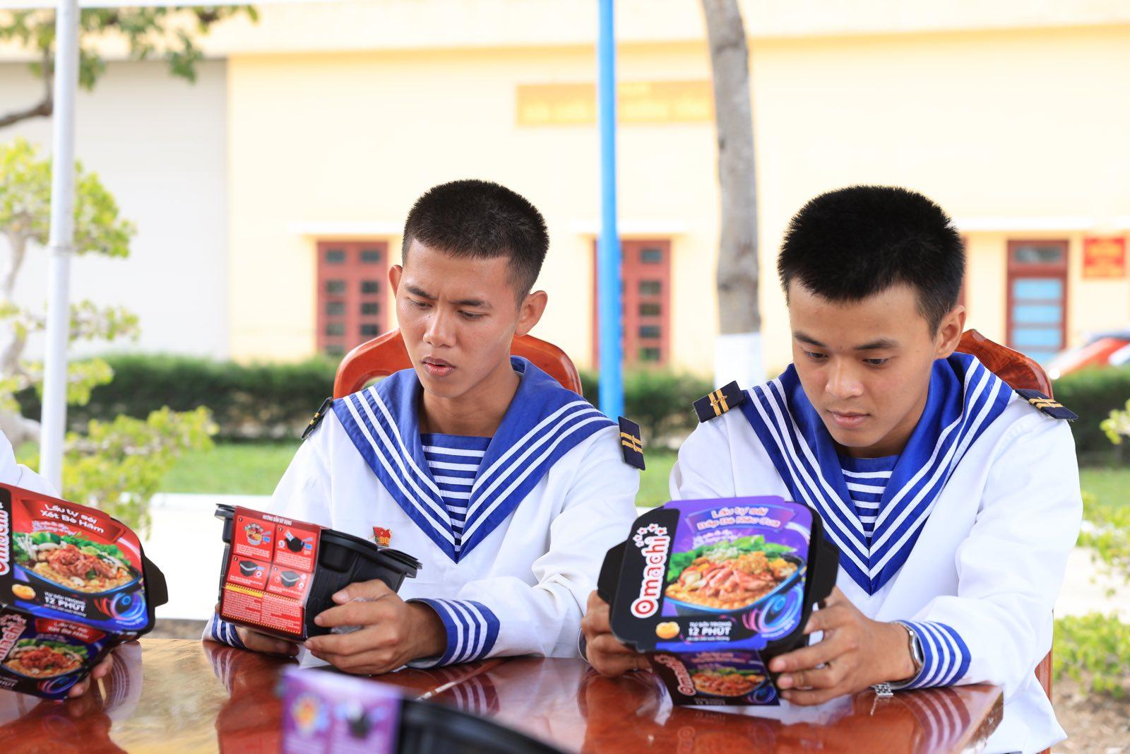 A couple of young men wearing sailor uniforms sitting at a table Description automatically generated