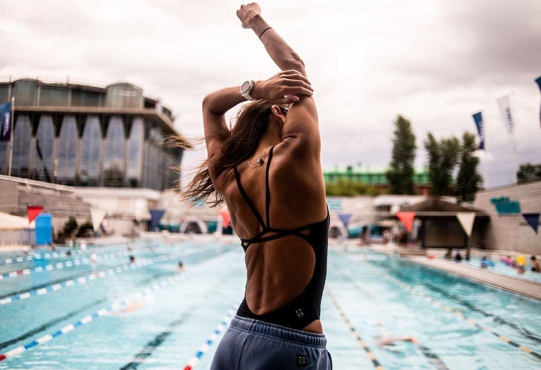 Swimmer in a backless swimsuit in front of a swimming pool&nbsp;