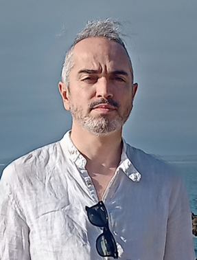 A person with a beard and mustache wearing a white shirtDescription automatically generated