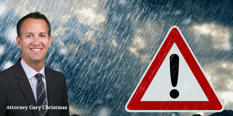 Experienced Car Accident Attorney Gary Christmas in front of a warning sign due to adverse weather conditions