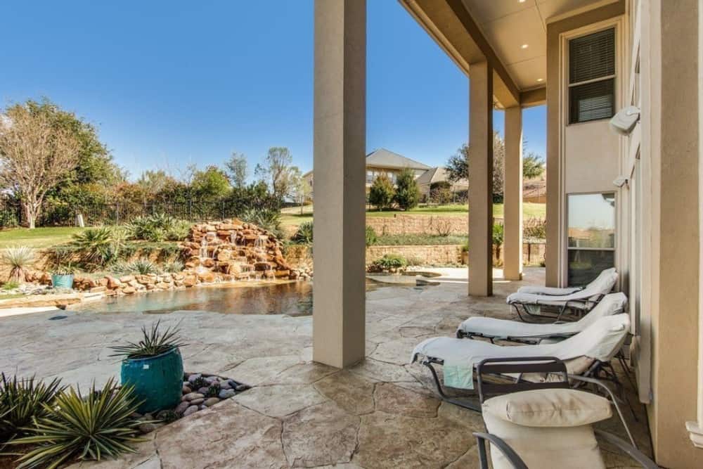 The lanai is furnished with metal loungers over the stone flooring.