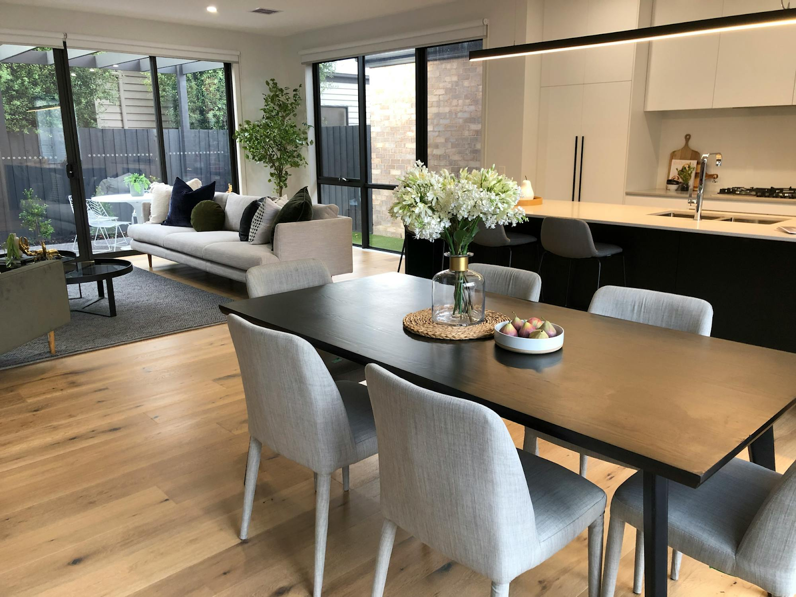 This image depicts sleek sliding glass doors in a sitting room, offering a wide view of the back porch. 