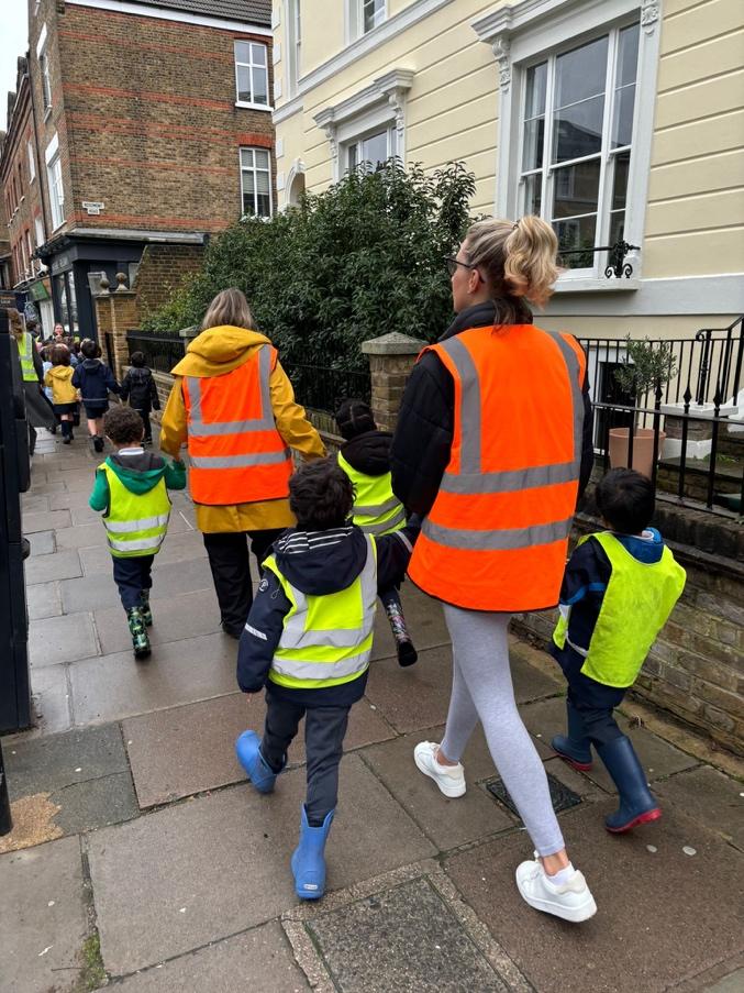 A group of people in reflective vests walking down a sidewalk

Description automatically generated