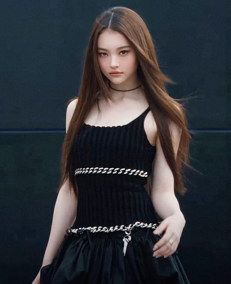 This contains an image of MEOVV Ella with long hair wearing a black dress