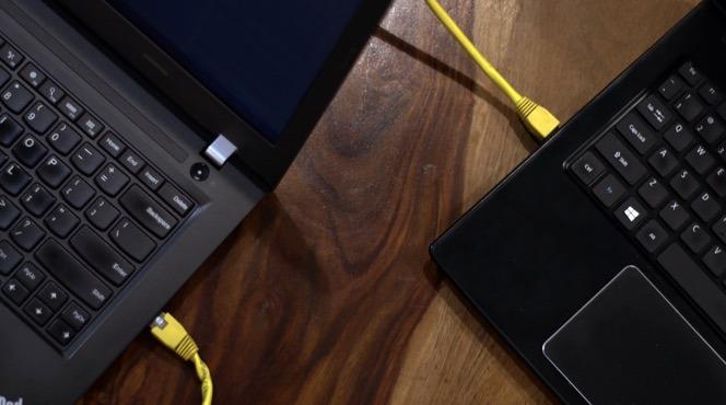 Two laptops connected to a wired Ethernet link during a large file transfer.