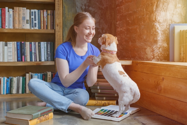 飼い主に前足を持ち上げられている犬