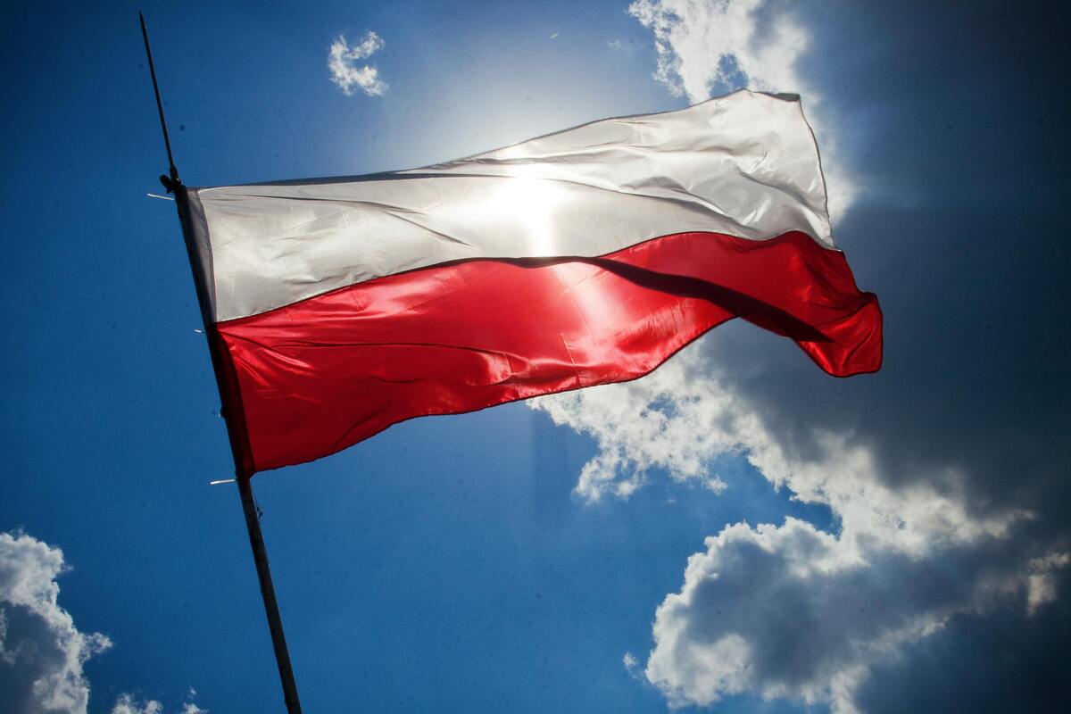 The national flag of Poland waving on a flagpole, symbolising Polish identity and international shipping destinations