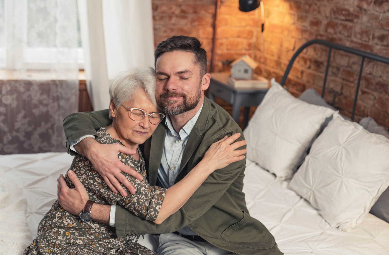 A man hugging his older adult mother.