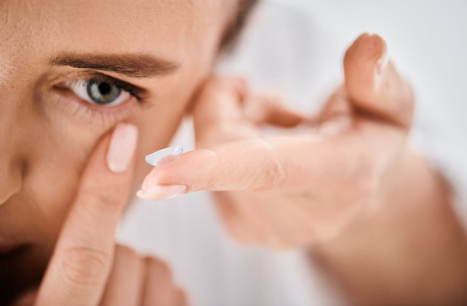 A person putting in contact lenses to help with blurry vision