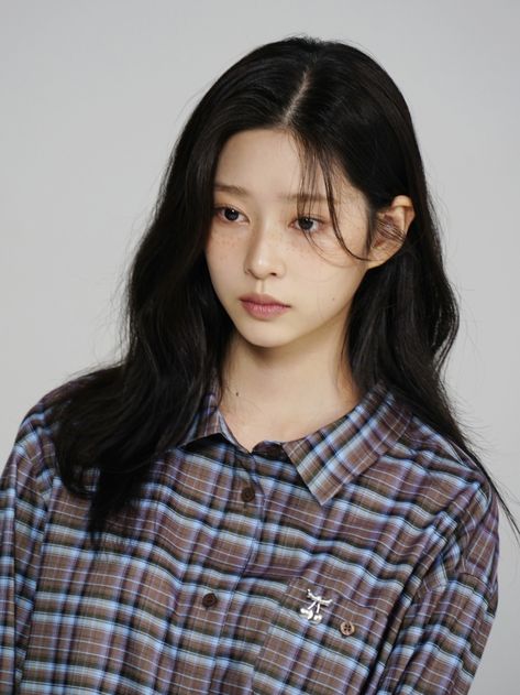 This contain a picture of kim Minju with long black hair wearing a plaid shirt