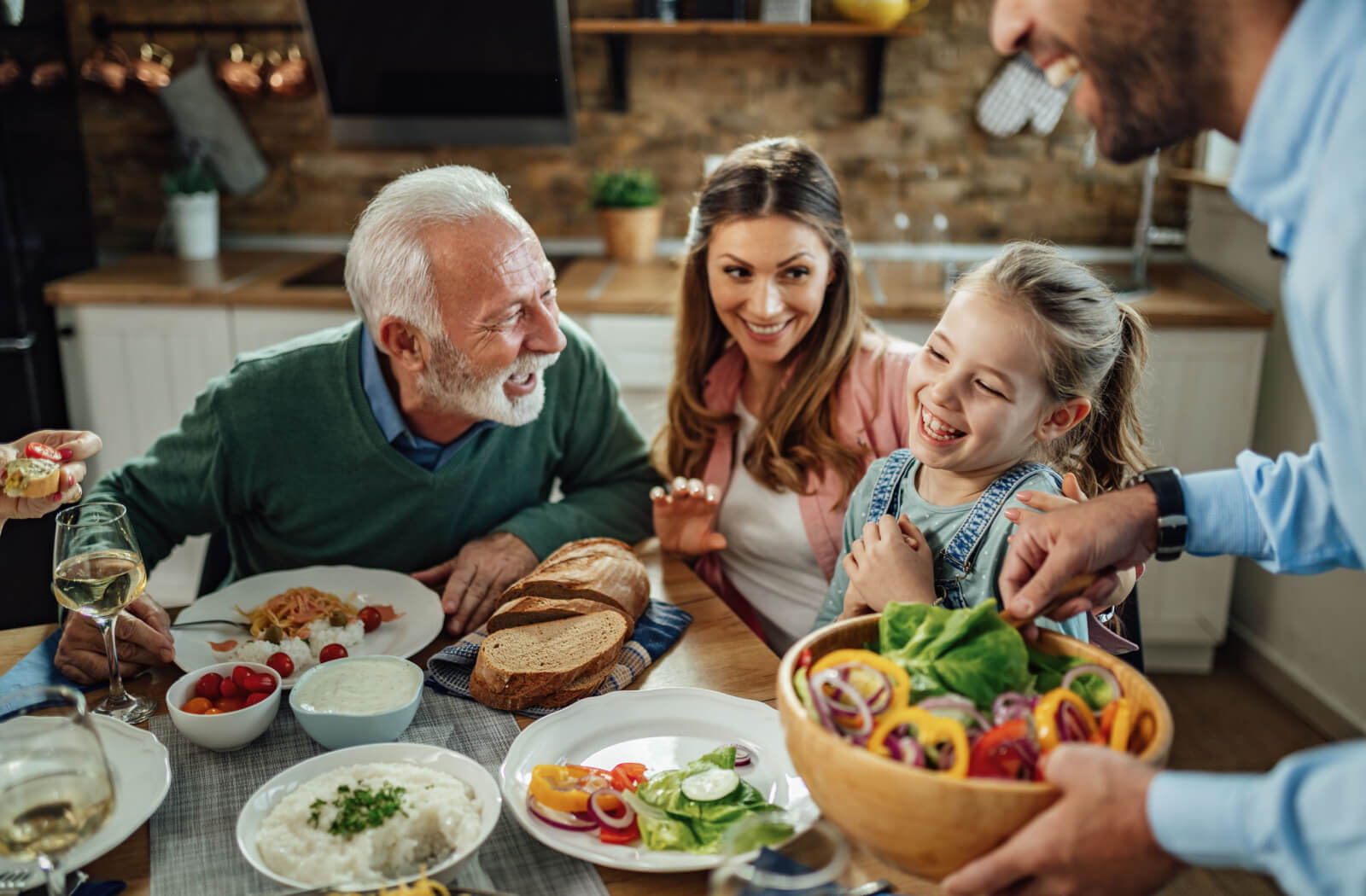 A cheerful senior enjoys a healthy dinner with family