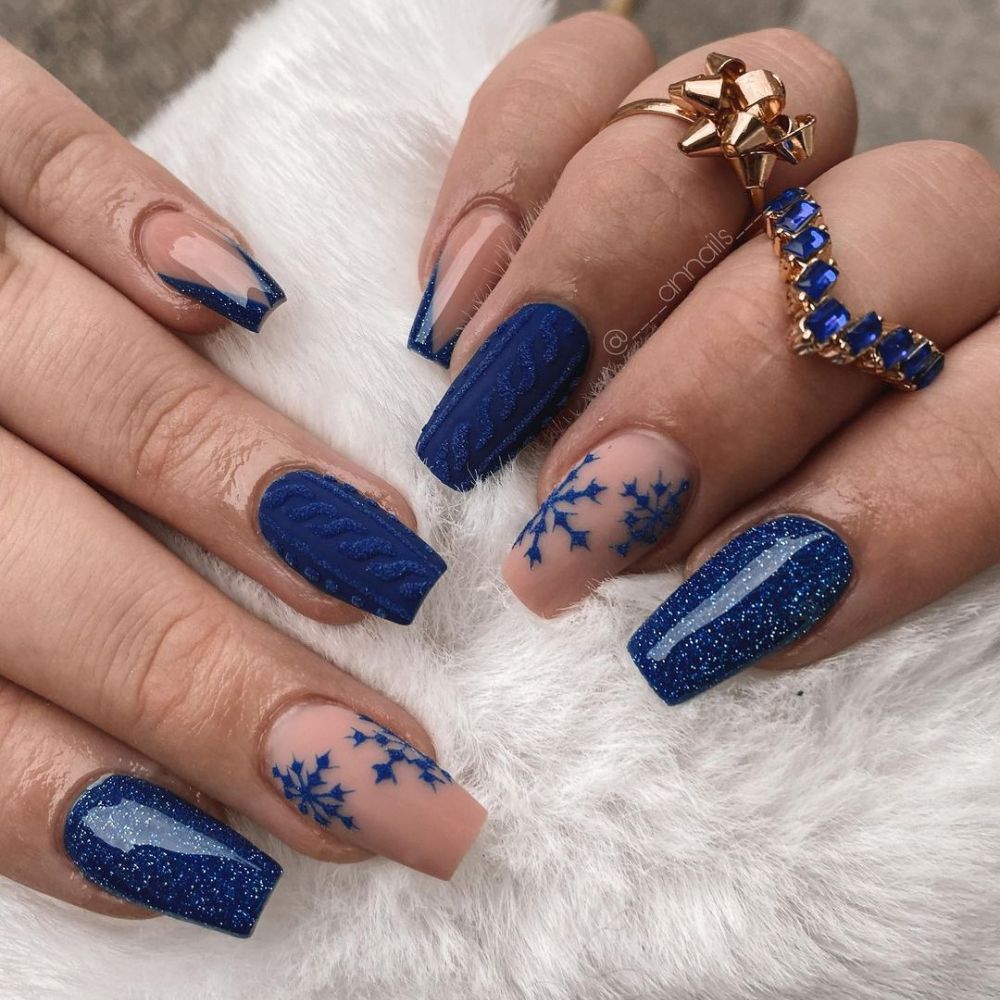 Close up of hands with blue winter nails having Royal Blue nail art