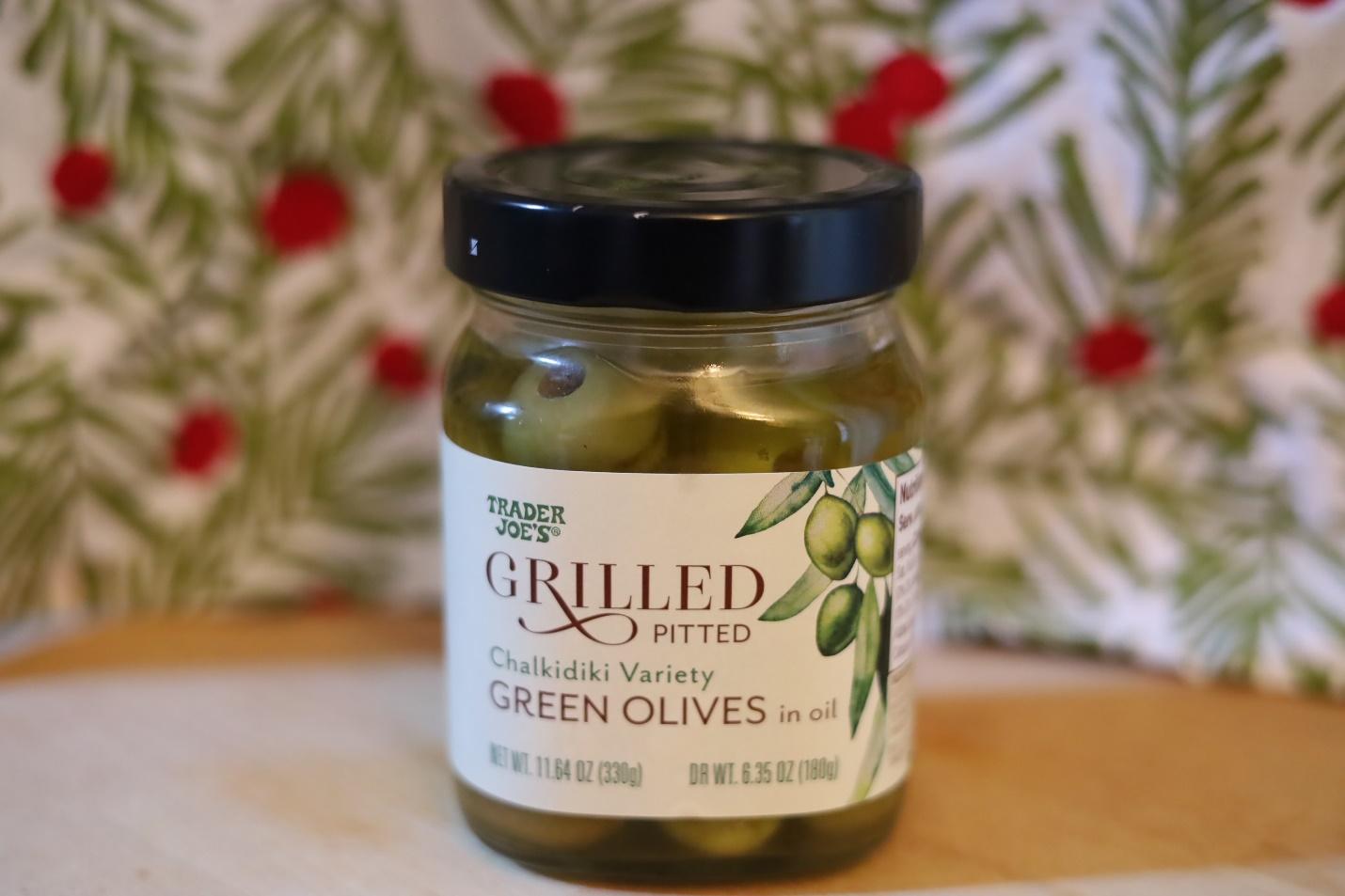 Jar of Trader Joe's grilled pitted green olivesDescription automatically generated