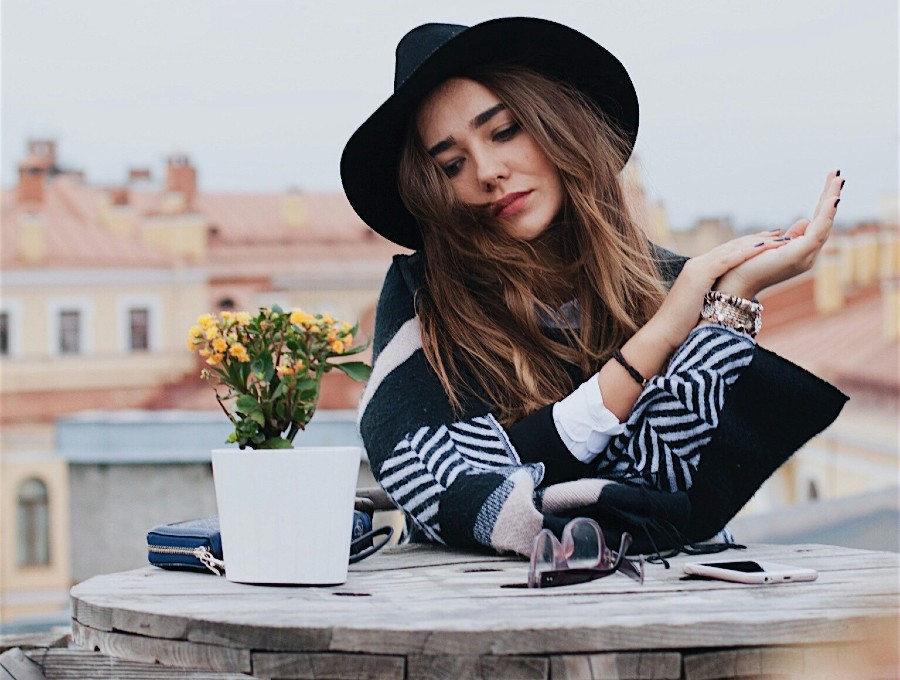 woman sitting beside table outdoors