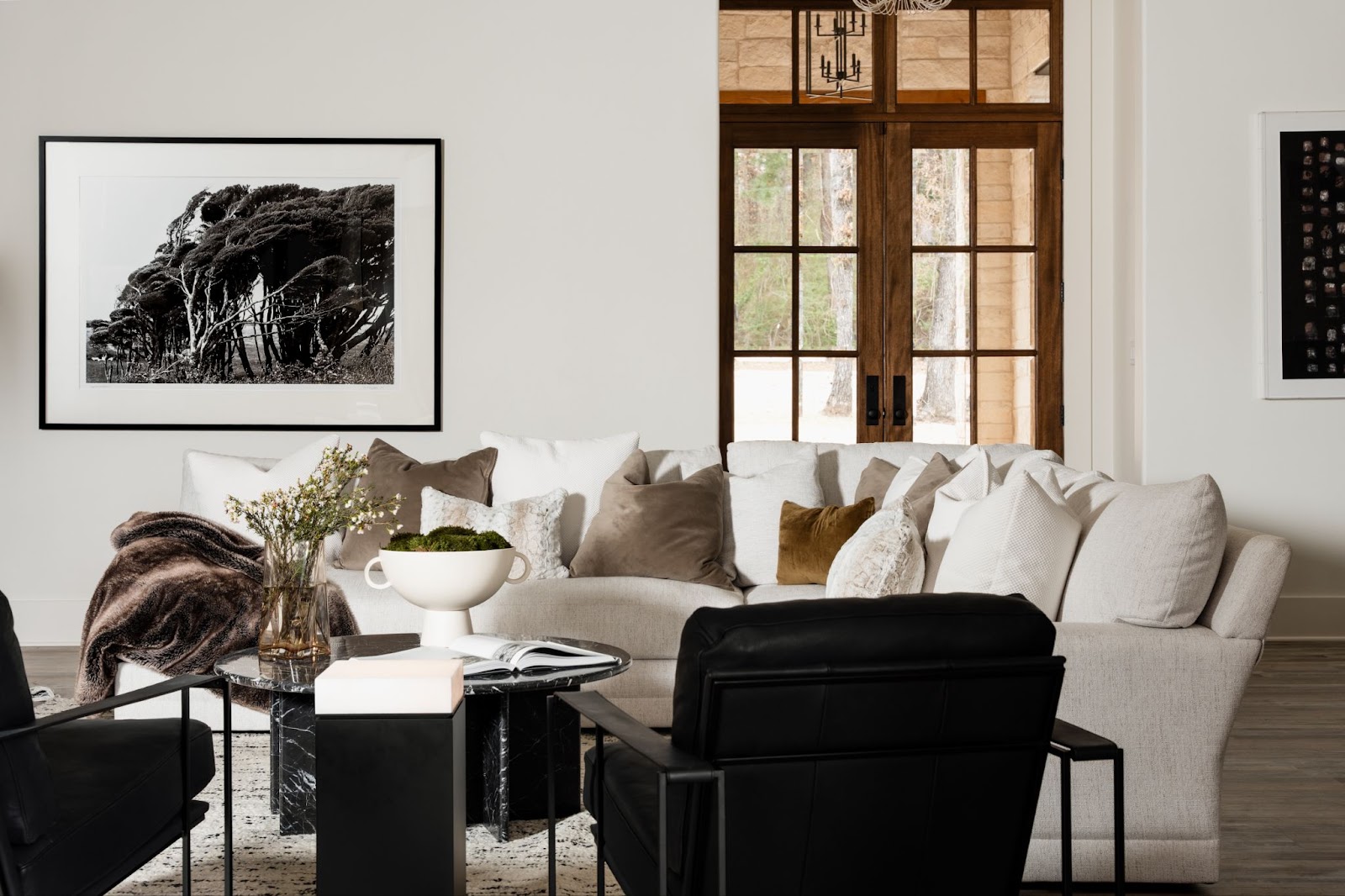 A part of a living room with a gray couch featuring artwork on the back depicting the correct height to hang a picture