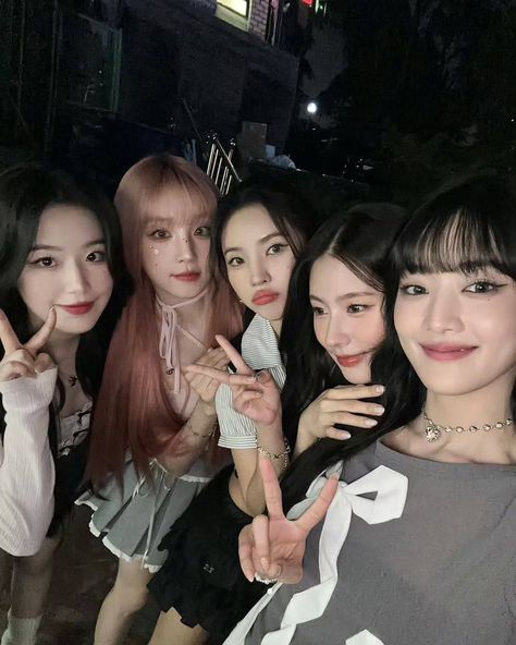 This  contain an image of GIDLE posing for the camera with their fingers in the air