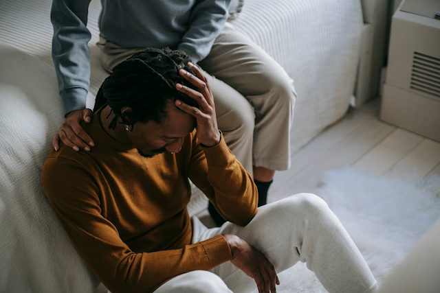 man being comforted by friend