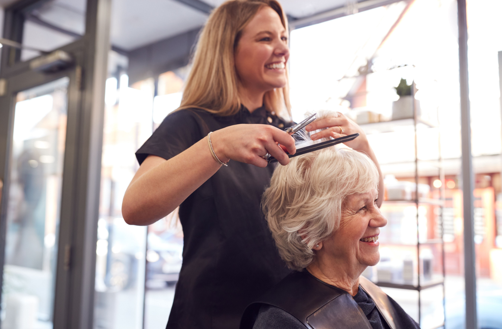 A senior resident sits for a trim at the community salon with their favourite stylist.