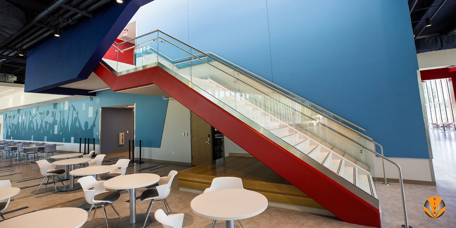 A glass railing system with metal bars on a stairwell. 