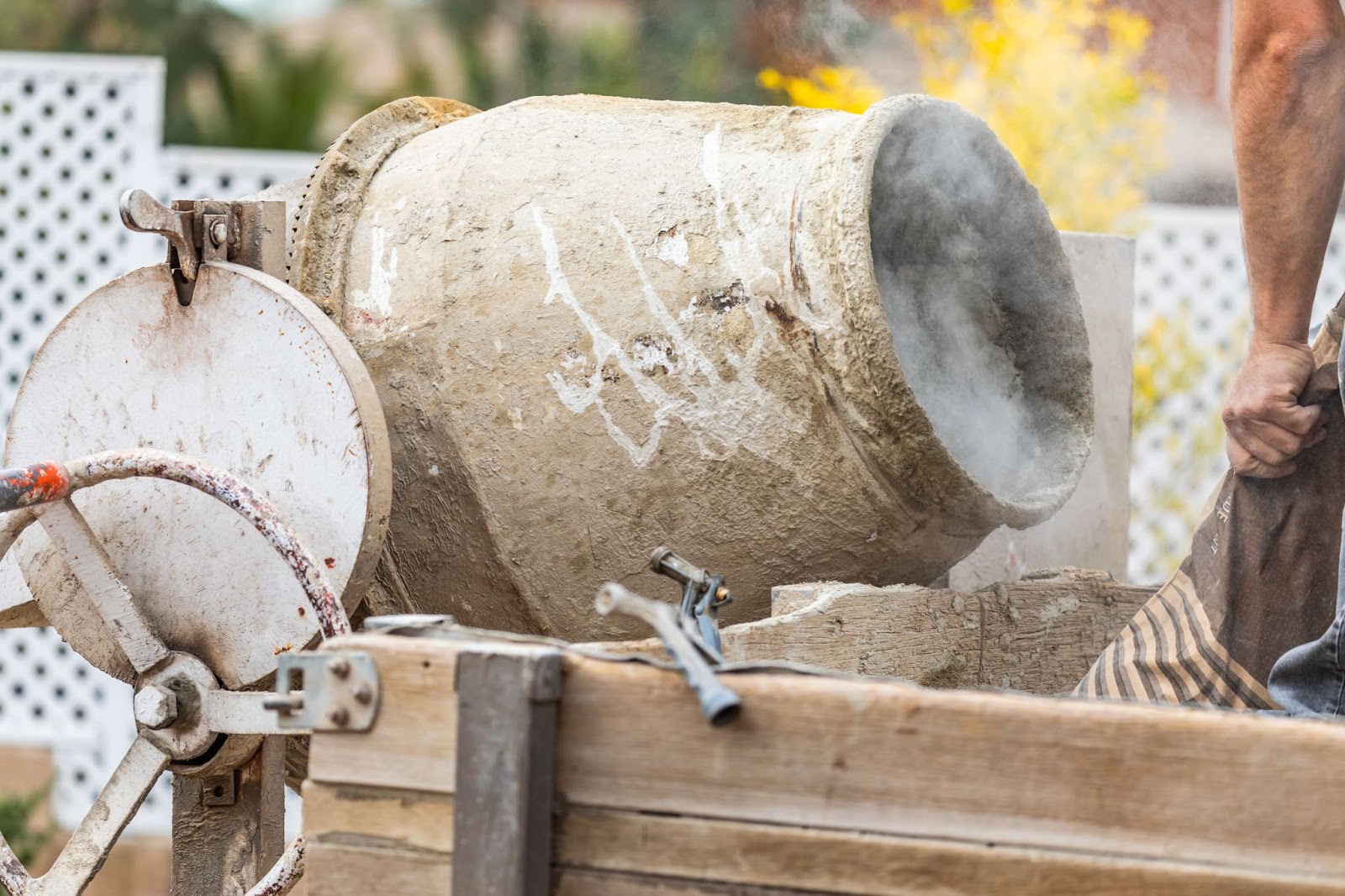 An image of a construction worker using mixing cement at a construction site. 