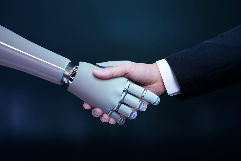 A robot and a human shaking hands, symbolizing collaboration between artificial intelligence and people in the workplace.