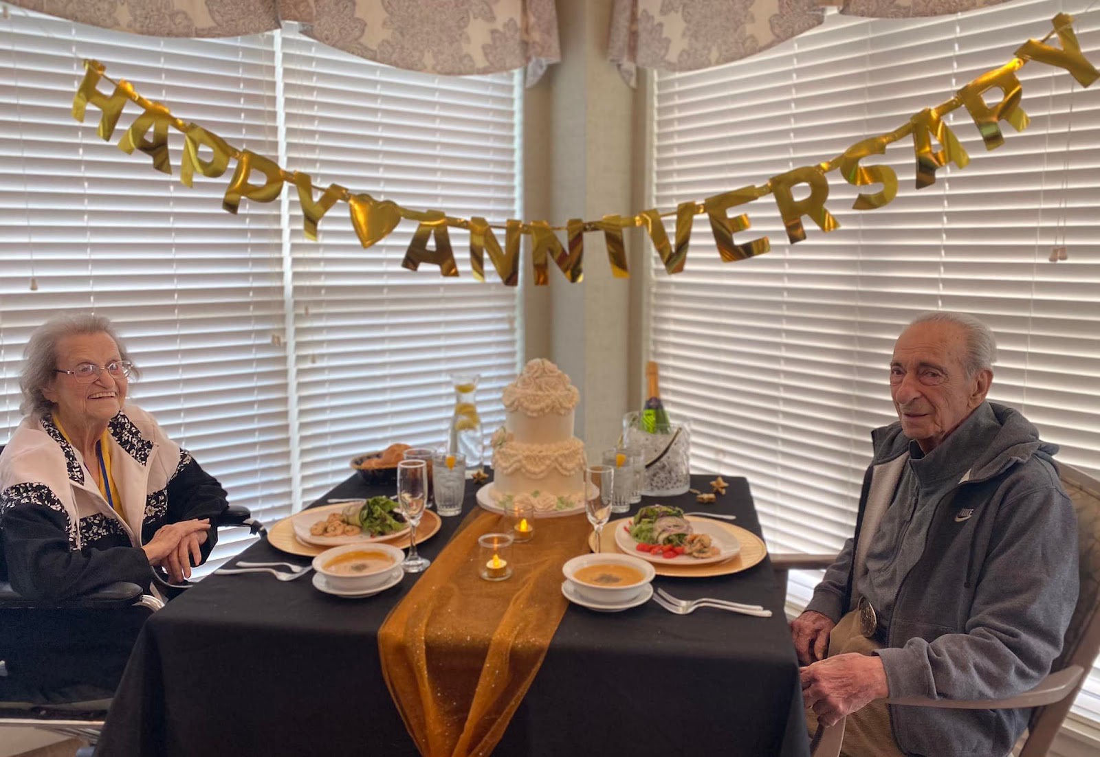 Senior citizens celebrating their anniversary at a table with food