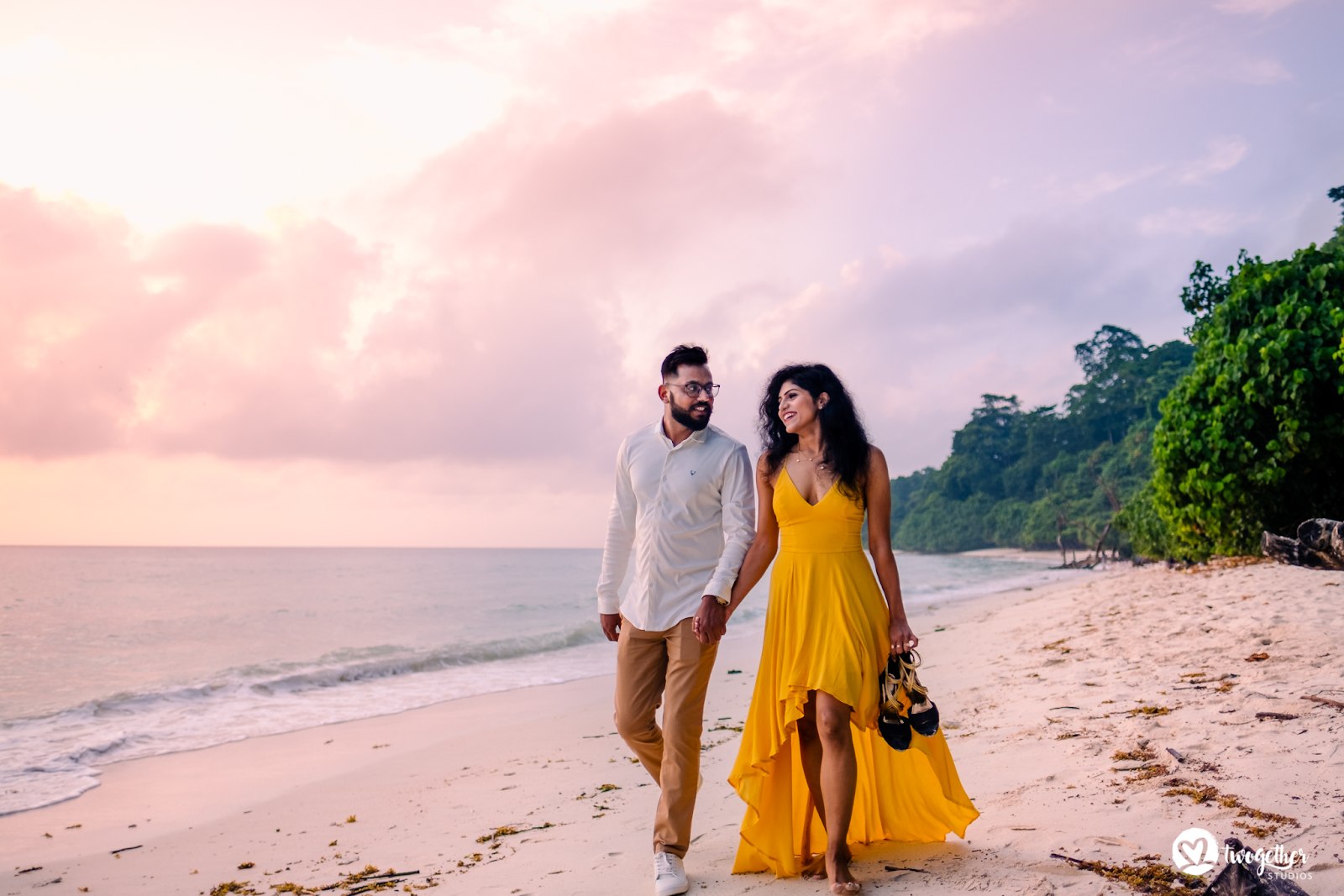 Couple walking hand-in-hand along the beach for a dreamy pre-wedding photoshoot