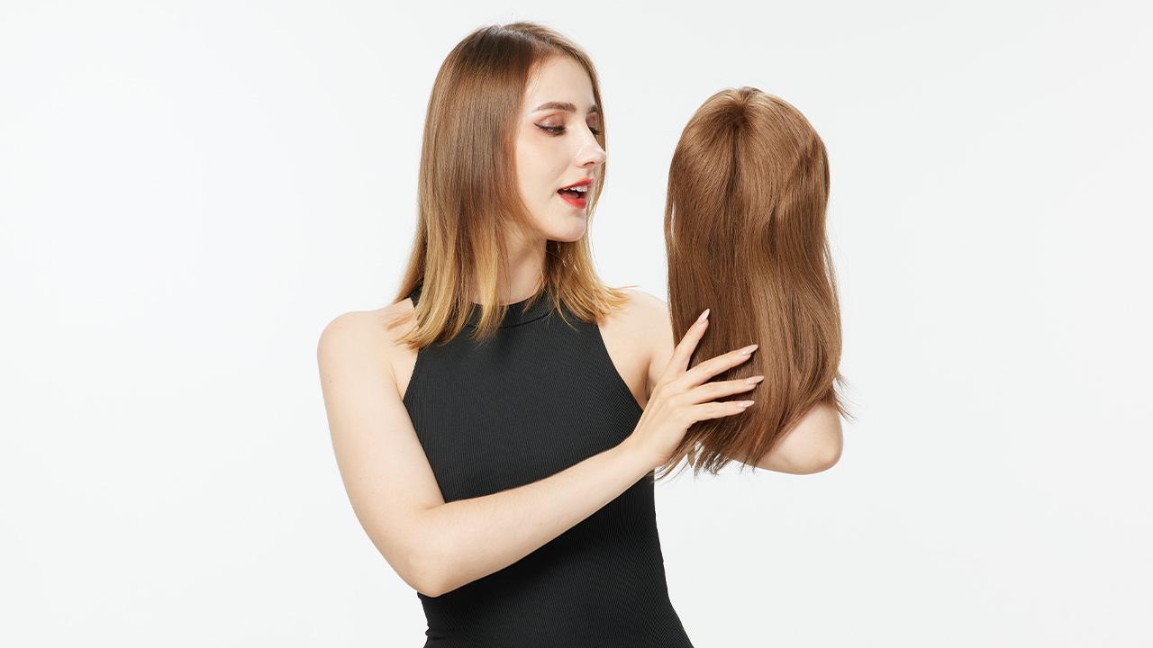 a woman in black dress holding a human hair topper