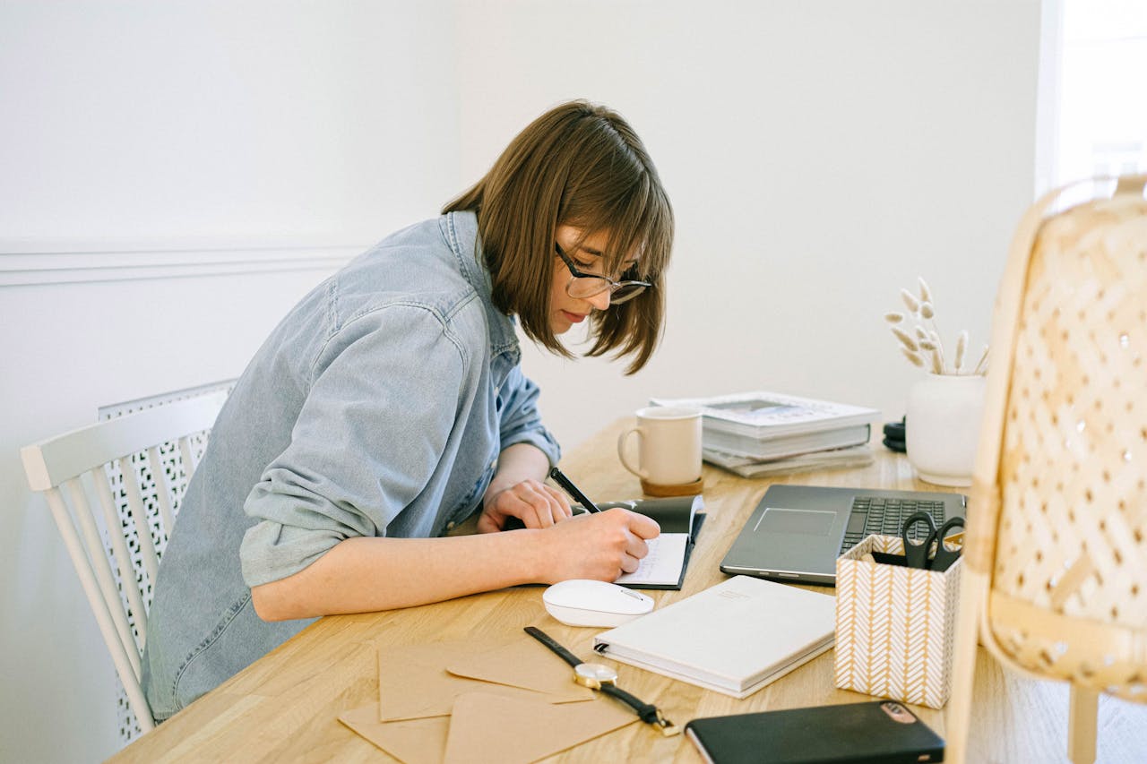 A woman focused on her writing down her tasks for the day.