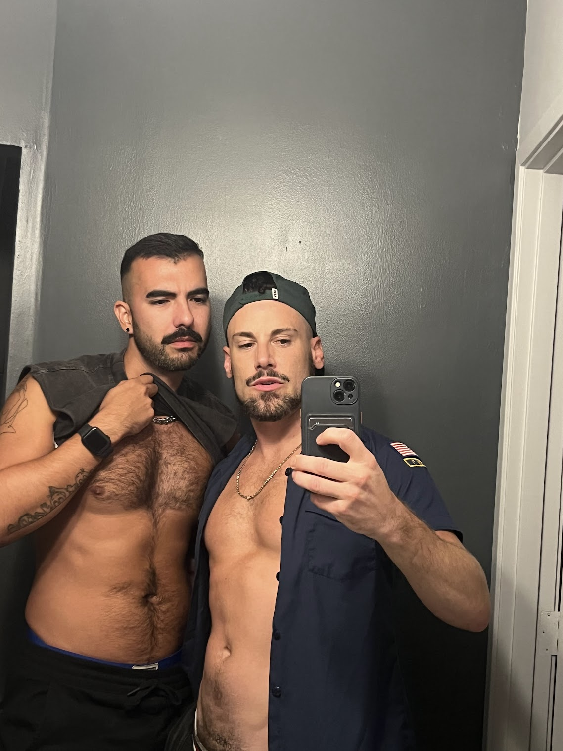 gay porn model phil and anonymous gay hookup UK lad taking iphone selfie in mirror showing off his tanned muscled torsos 