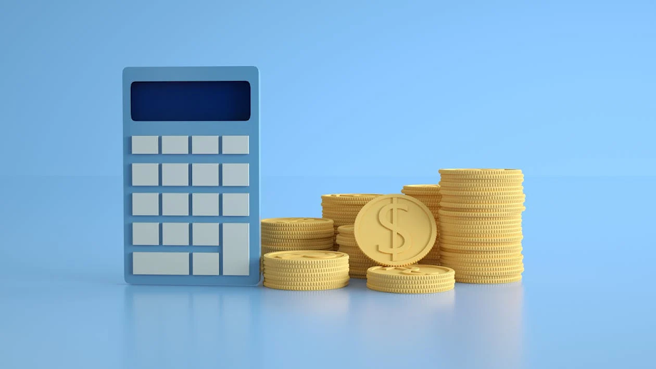 Calculator with gold coins and dollar symbol on a light blue background, representing financial success and investment strategies.