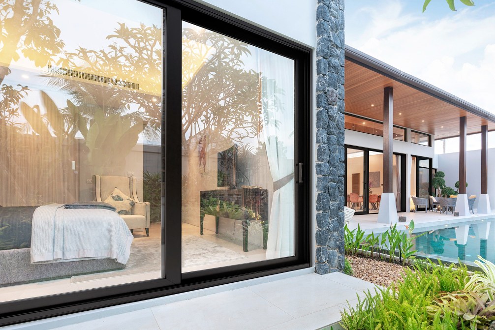 This image depicts an exterior view of a bedroom with a large sliding glass door with a black frame.