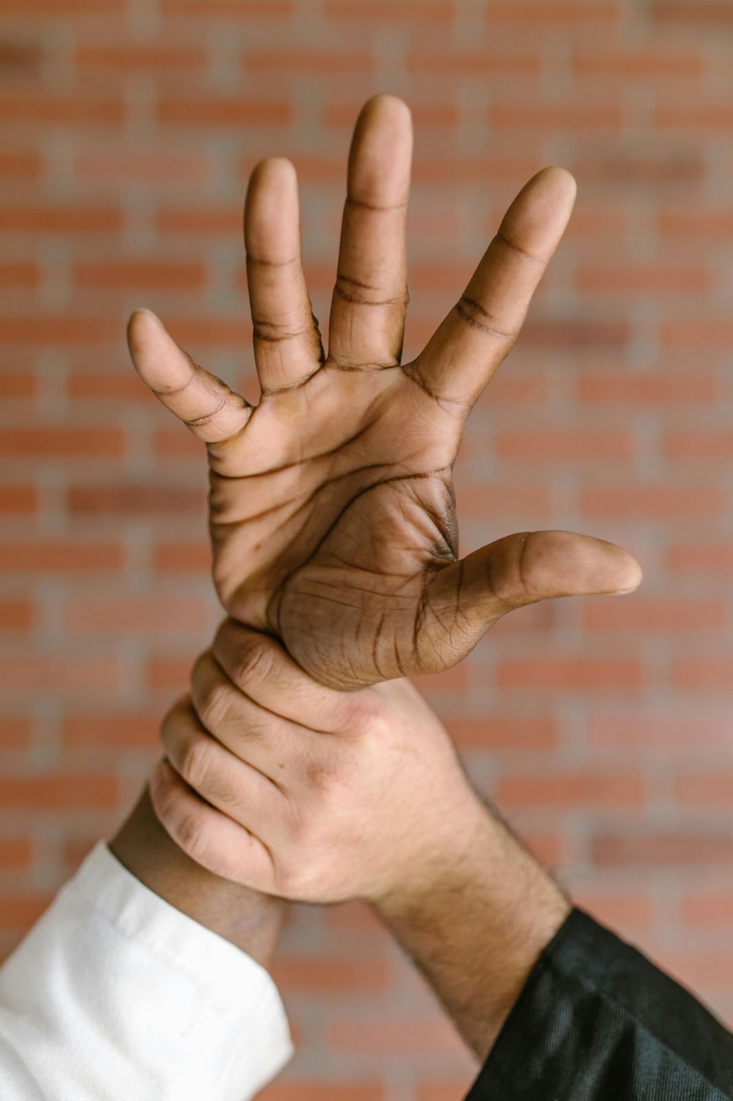 A martial arts instructor performs a writlock technique on a student