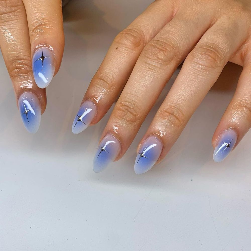 Close up of hands with blue winter nails having Airbrushed Nails