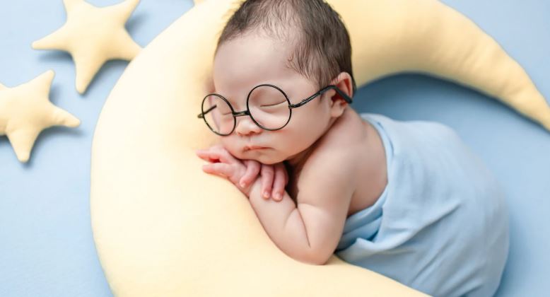 better sleep quality after wearing blue light glasses: A baby sleeping on a yellow pillow wearing glasses