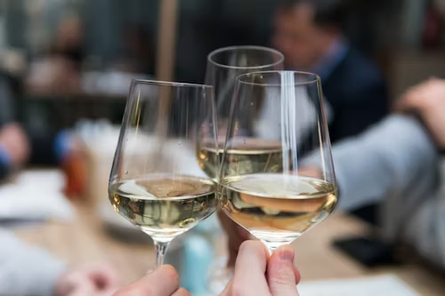 Three glasses of drinks. with the holders cheering with eachother