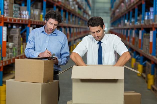Managers are checking some cardboard boxes