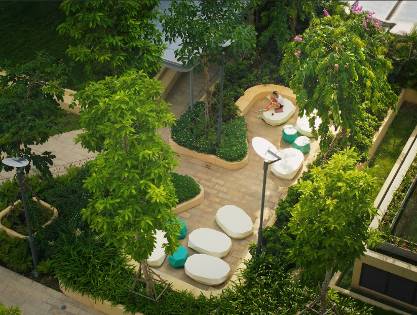 A person sitting on a bench in a courtyard surrounded by treesAI-generated content may be incorrect.