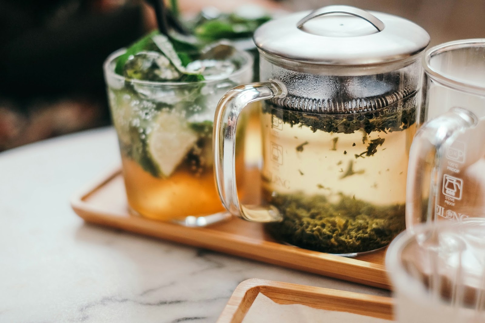 A glass teapot with tea leaves brewing